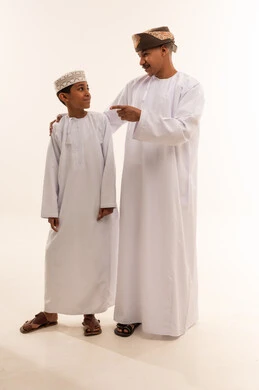 Omani Man and Boy in Traditional Dishdasha and Kumma