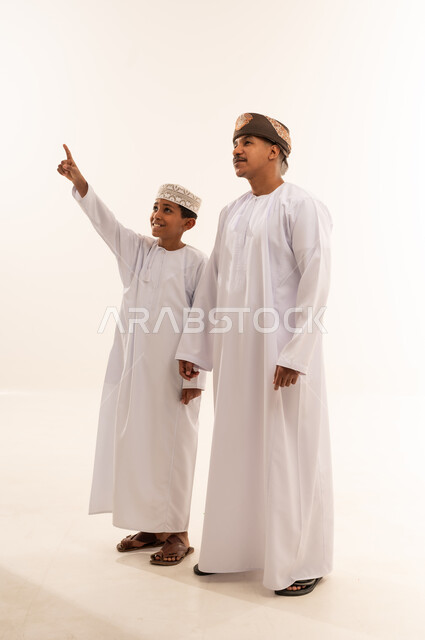 Omani Man and Boy in Traditional Dress Pointing