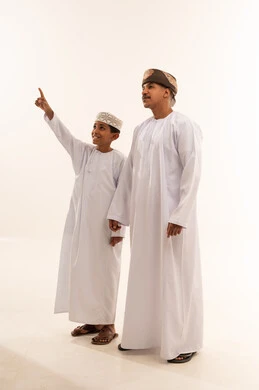 Omani Man and Boy in Traditional Dress Pointing