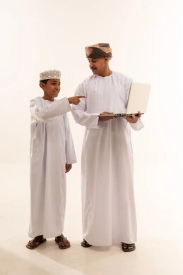 Omani Man and Boy Using Laptop on White Background