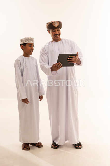 Omani Man and Boy Using Tablet in Studio