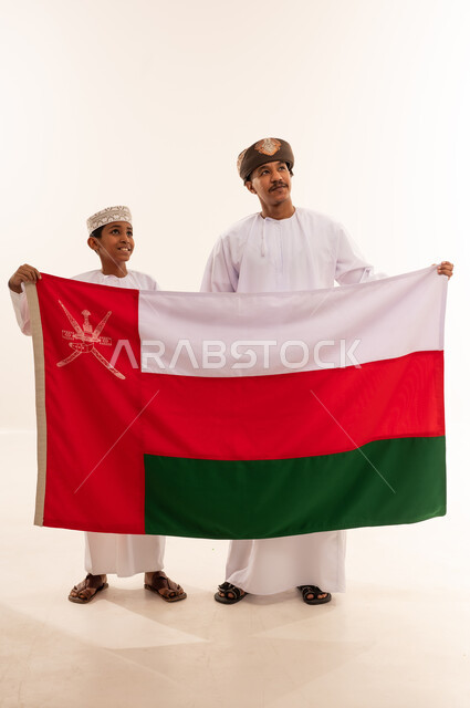 رجل وطفل عمانيان يمسكان بعلم سلطنة عمان