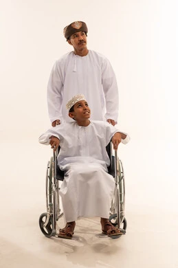 Omani Man and Boy in Wheelchair on White Background