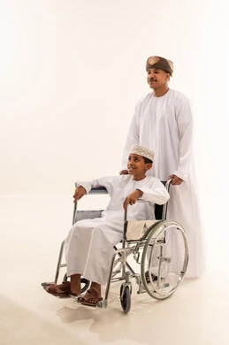 Omani Man and Boy in Wheelchair on White Background