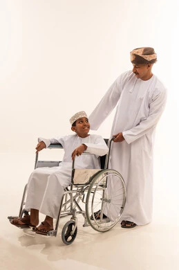 رجل وطفل عماني على كرسي متحرك في الاستوديو
