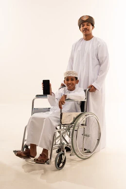 Omani Man and Boy in Wheelchair with Smartphone