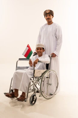 Omani Man and Boy in Wheelchair with Flag