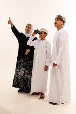 Omani Family in Traditional Dress Using Binoculars