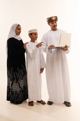 Omani Family Using Laptop in White Studio