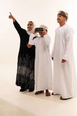 Omani Family Using VR Headset in Traditional Clothing