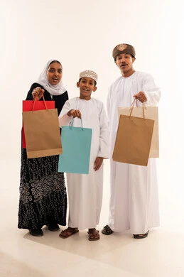 عائلة عمانية تحمل حقائب تسوق في الاستوديو