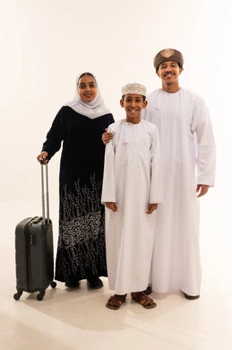 عائلة عمانية مع حقيبة سفر في الاستوديو