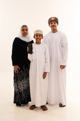 Omani Family Holding Smartphone in Traditional Dress