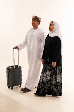 Omani Couple in Traditional Dress with Suitcase
