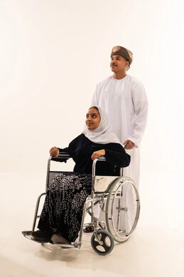رجل عماني مع امرأة على كرسي متحرك في الاستوديو