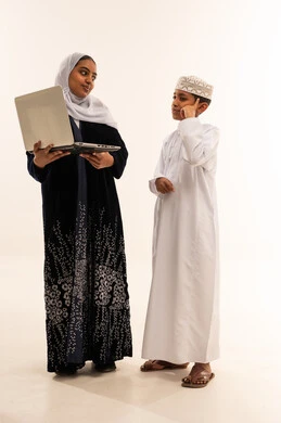 امرأة عمانية وطفل مع لابتوب في الاستوديو