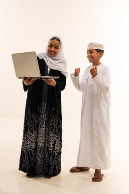 Omani Mother and Son Celebrating with Laptop in Studio