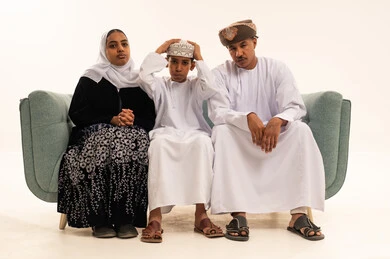 عائلة عُمانية بالزي التقليدي على الأريكة في استوديو