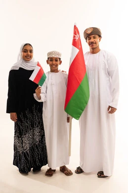 عائلة عُمانية تحمل أعلام سلطنة عُمان بالزي التقليدي عائلة عُمانية تحمل أعلام سلطنة عُمان بالزي التقليدي