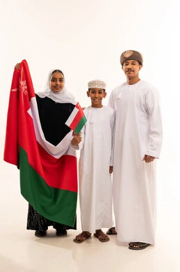 Omani Family in Traditional Dress Holding Oman Flag