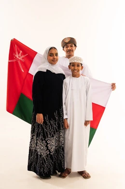 عائلة عمانية تحمل العلم الوطني في استوديو عائلة عمانية تحمل العلم الوطني في استوديو
