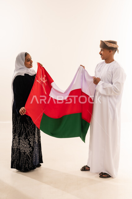 رجل وامرأة من عمان يحملان علم السلطنة