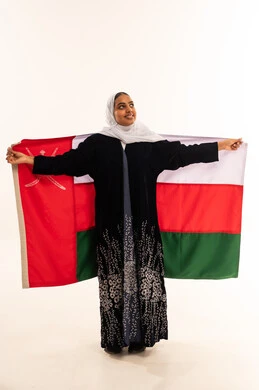 Omani Woman Holding National Flag in Traditional Abaya
