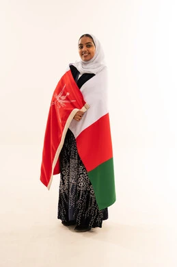 امرأة عمانية مع العلم الوطني بخلفية بيضاء
