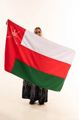 امرأة عُمانية تحمل العلم الوطني العُماني في الاستوديو