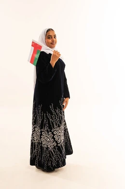 امرأة عمانية تحمل علم عمان في الاستوديو