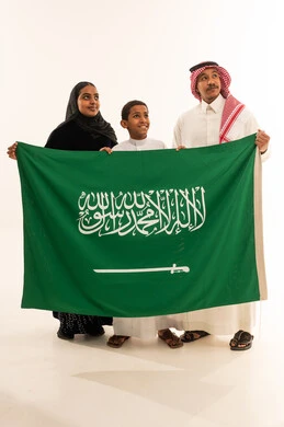 Saudi Family Holding National Flag in Studio