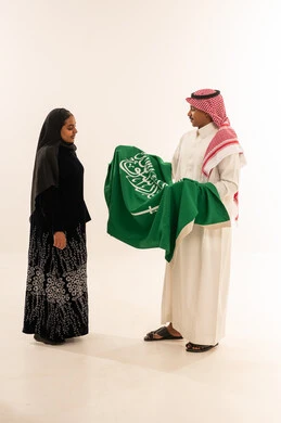 Saudi Couple Holding National Flag on White Background