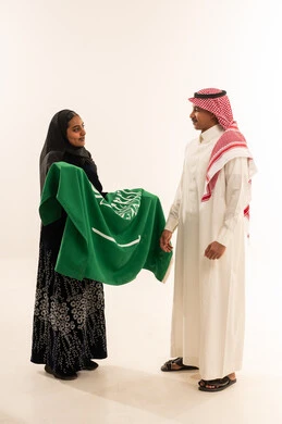زوجين سعوديين يحملان العلم الوطني في الاستوديو