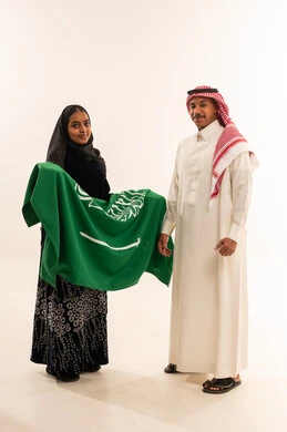 Saudi Couple Holding National Flag in Studio