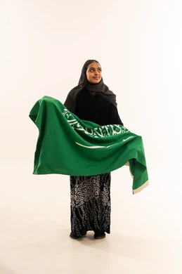 امرأة سعودية تحمل العلم الوطني في استوديو