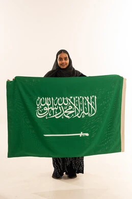 Saudi Woman Holding Saudi Arabia National Flag in Studio