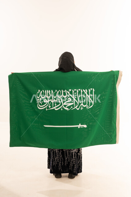 امرأة سعودية تحمل العلم الوطني على خلفية بيضاء