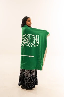 Saudi Woman Wrapping Saudi Arabia Flag in Studio