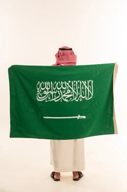 Saudi Man Holding Saudi Arabia Flag from Behind