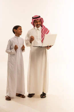 أب سعودي وابنه يحتفلان بالنجاح باستخدام الحاسوب