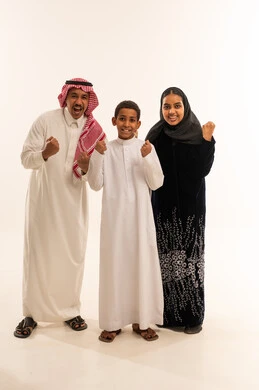 عائلة سعودية تحتفل بالزي التقليدي أمام خلفية بيضاء