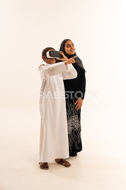 طفل سعودي يستخدم نظارة الواقع الافتراضي مع امرأة عربية