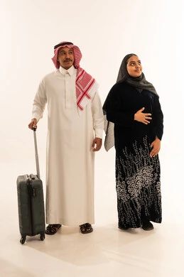 زوجين سعوديين مع حقيبة سفر في الاستوديو