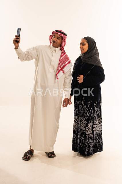 زوجان سعوديان يلتقطان صورة سيلفي بالهاتف الذكي