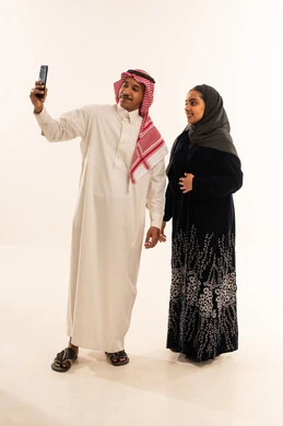 زوجان سعوديان يلتقطان صورة سيلفي بالهاتف الذكي
