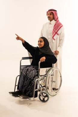 امرأة سعودية على كرسي متحرك مع رجل سعودي