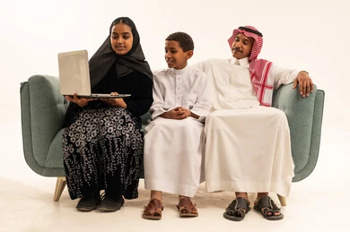 Saudi Family with Laptop on Sofa White Background