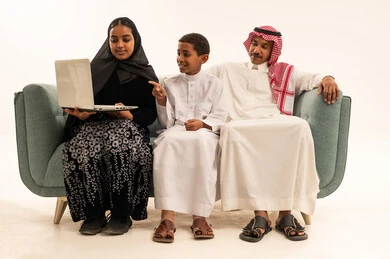 Saudi Family Using Laptop on Sofa in Studio