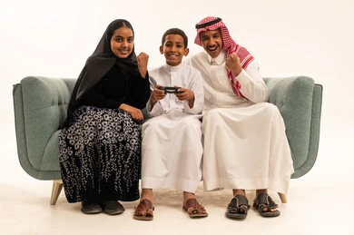 عائلة سعودية تلعب ألعاب الفيديو على الأريكة عائلة سعودية تلعب ألعاب الفيديو على الأريكة