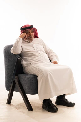 رجل سعودي مسن يجلس على كرسي في الاستوديو